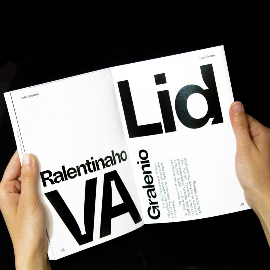 Person hold the specimens book of Rale Grotesk Family